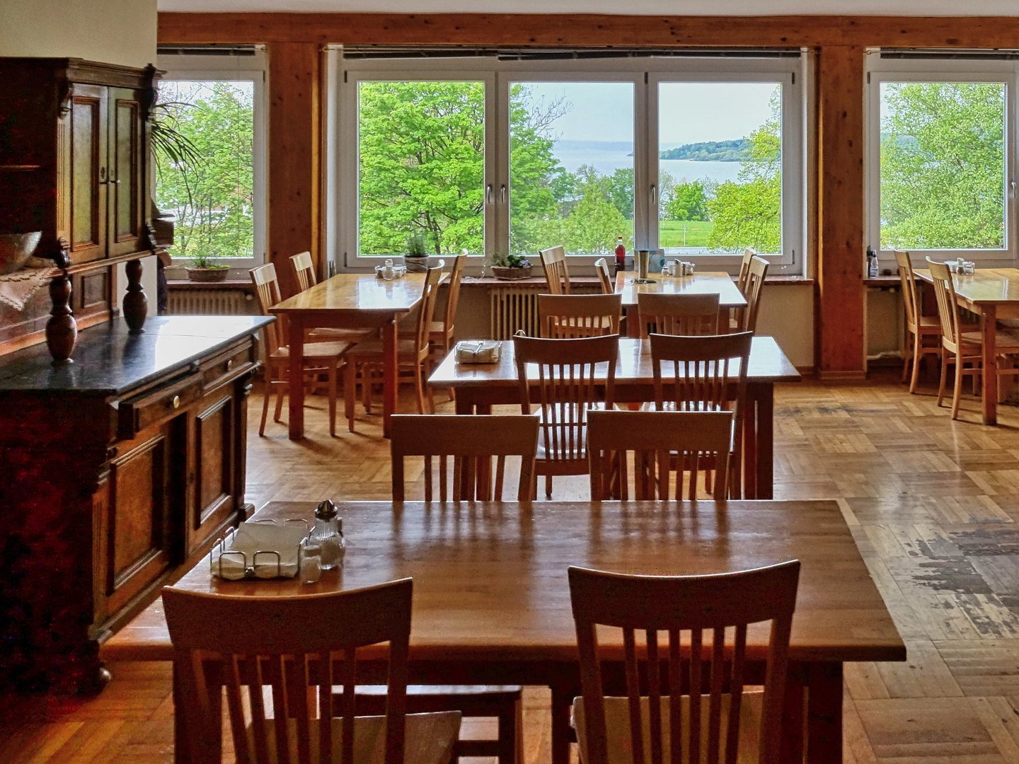 Speisesaal: große Fenster mit Blick zum See - schönem, alten Parkettboden und gemütlicher Holzeinrichtung