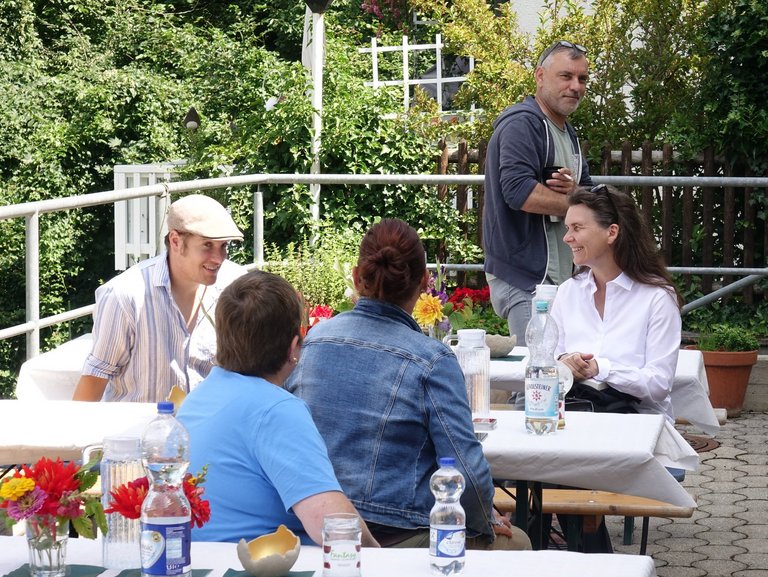 auf der Terasse - eine Gruppe Frauen und Männer unterhalten sich