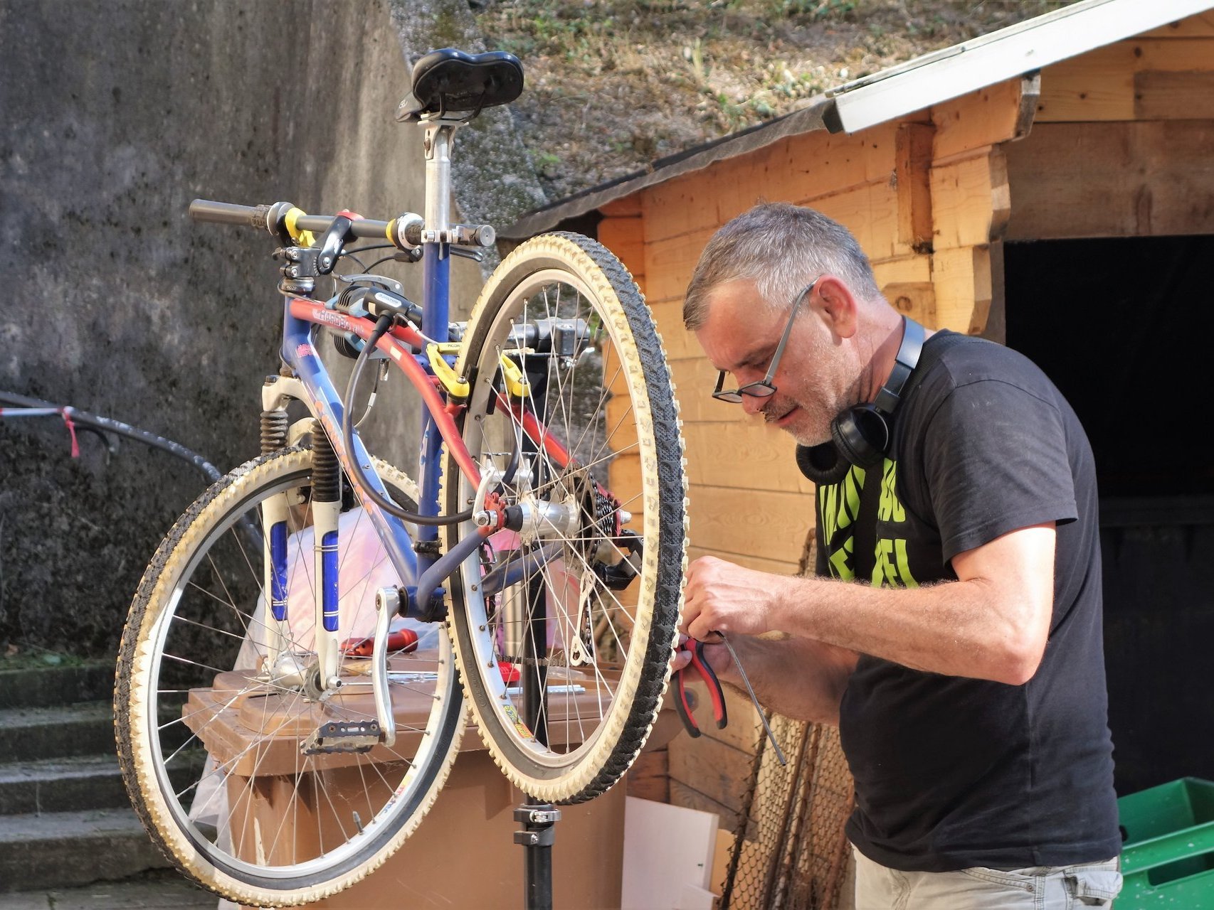 Ein Mann repariert ein Fahrrad, das in einen Fahrradständer eingespannt ist